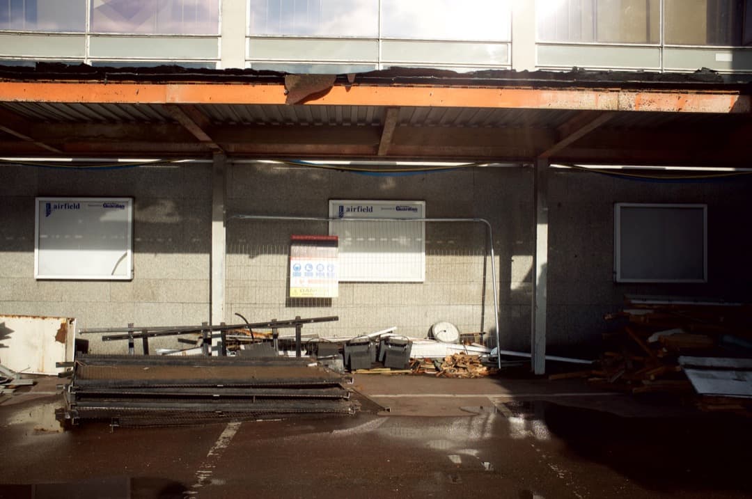 Photo of television monitors and cladding pilled up outside a building